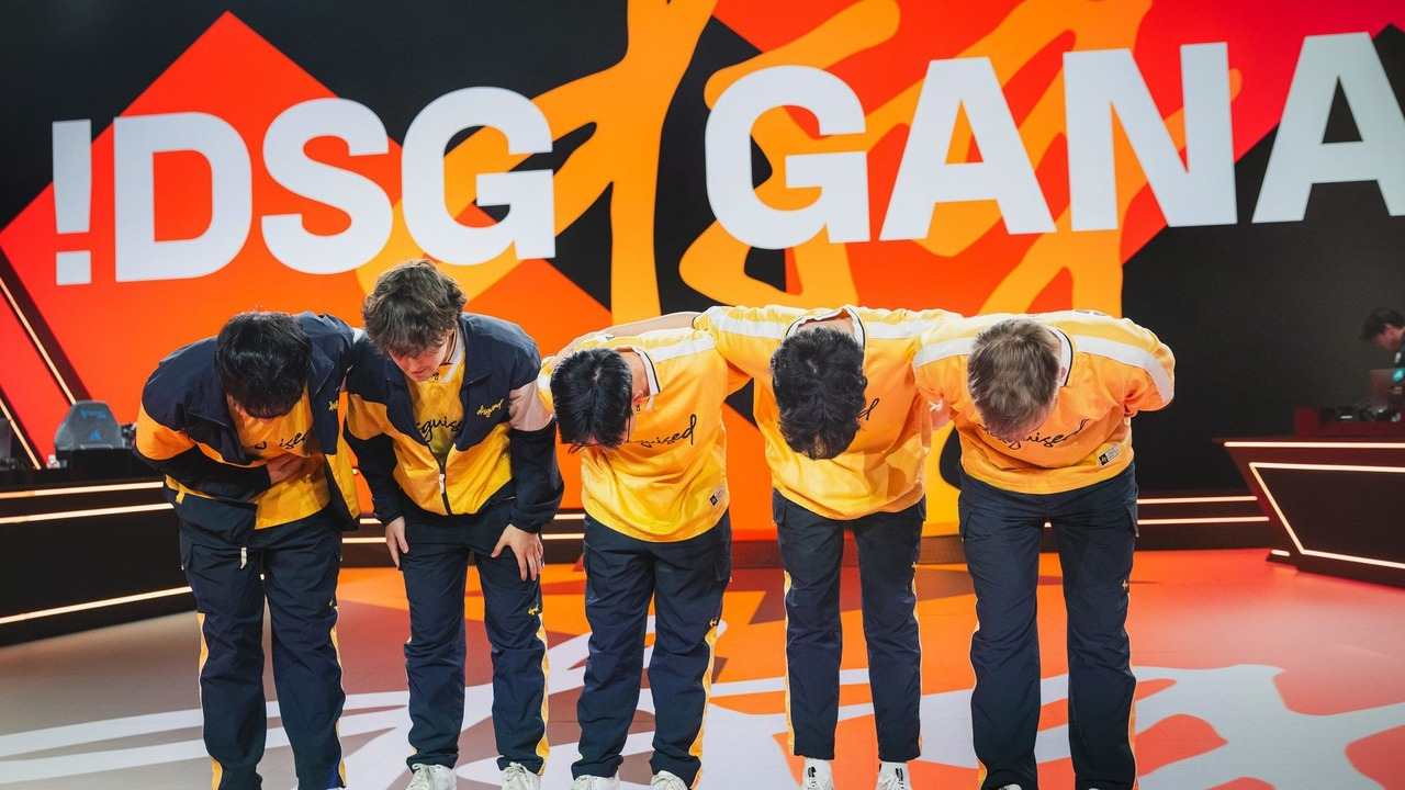 Disguised League of Legends players bow together on stage